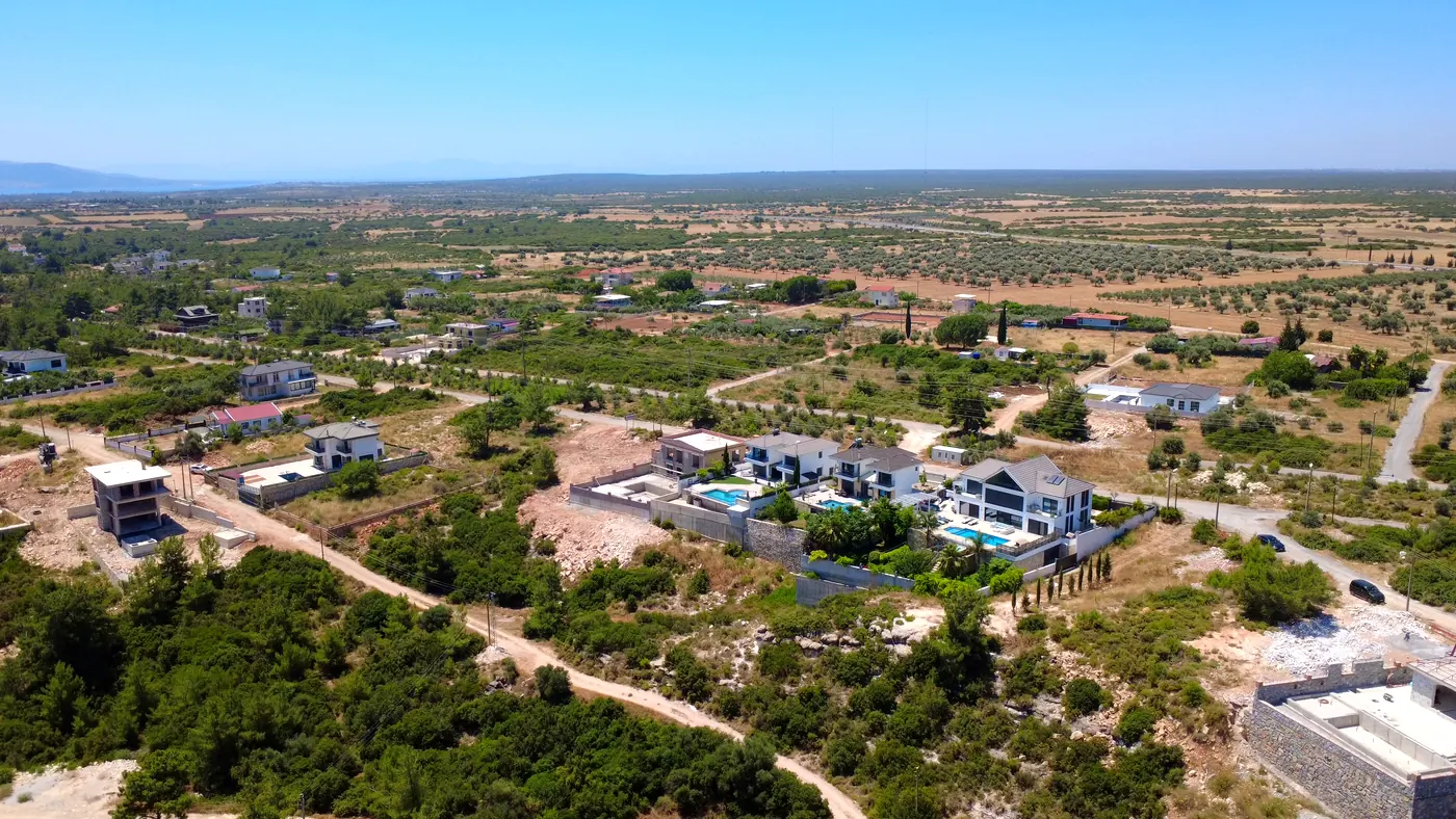 Вид с дрона: современные виллы с бассейнами у оливковых рощ в Seyrantepe, Дидим